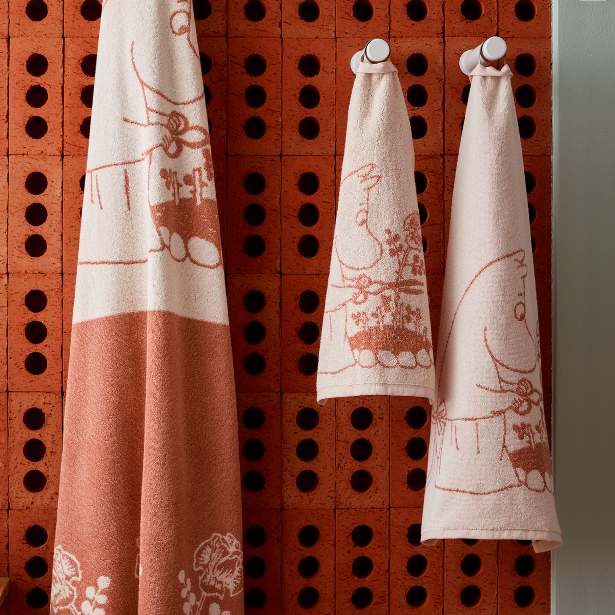 Moomin hand towel 30x50cm Moominmamma beige - Moominmamma beige towels hanging in a bathroom.