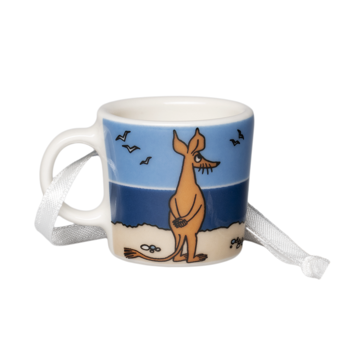 Mumin mini mugg Sniff - A small ceramic mini mug with a printed illustration of Sniff on a beach under a blue sky, with a white ribbon tied around its handle, shown on a plain white background.