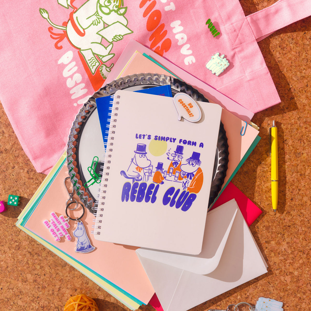 Muumi muistivihko Rebel Club - Notebook with 'Rebel Club' design on a cork surface with stationery items.