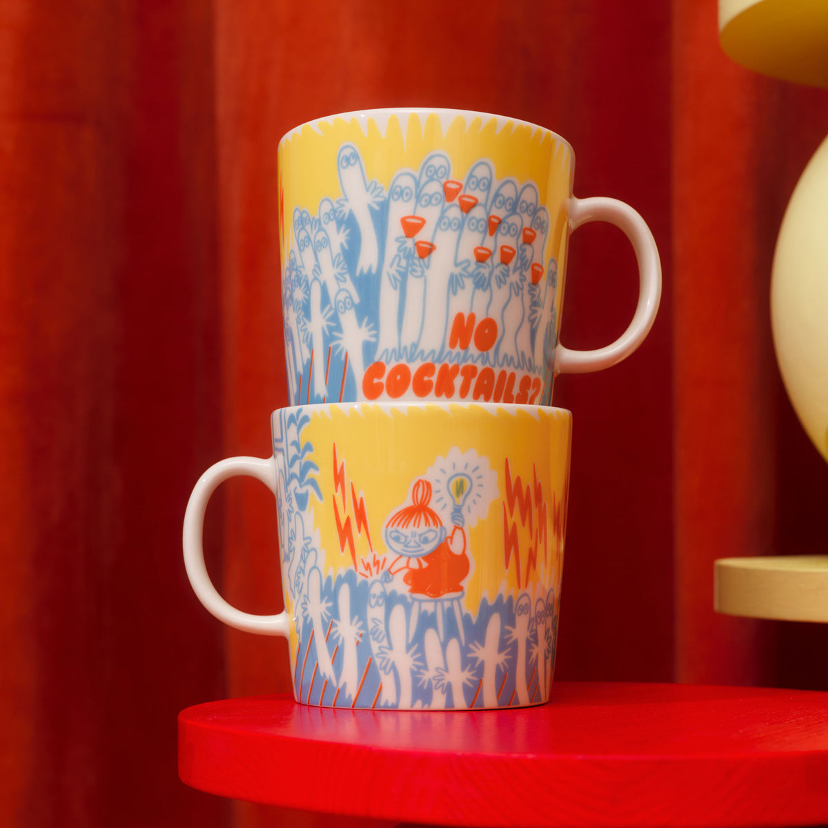 Mummi kopp 0,4 l Party Queue - Two Party Queue mugs stacked on a red stool with a red curtain background
