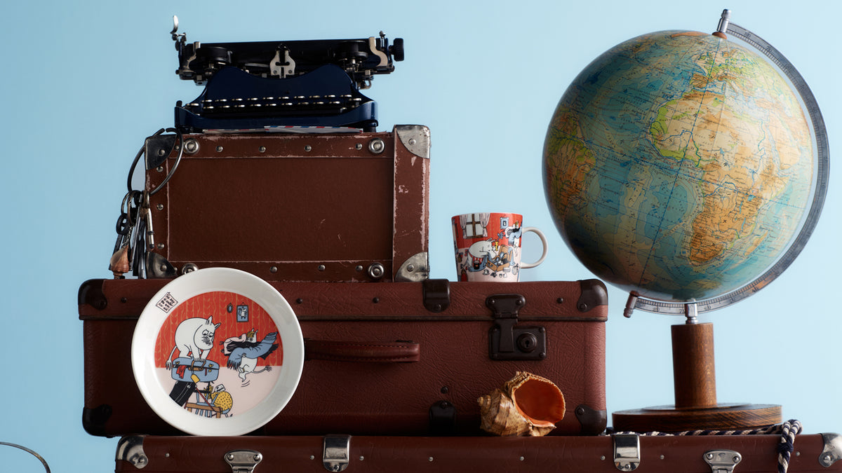 Stack of vintage suitcases with Holiday Rush items against a blue background.