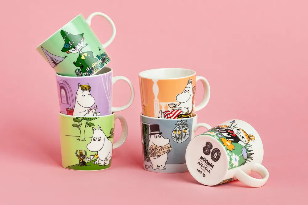 Set of colorful moomin classics mugs on a pink background