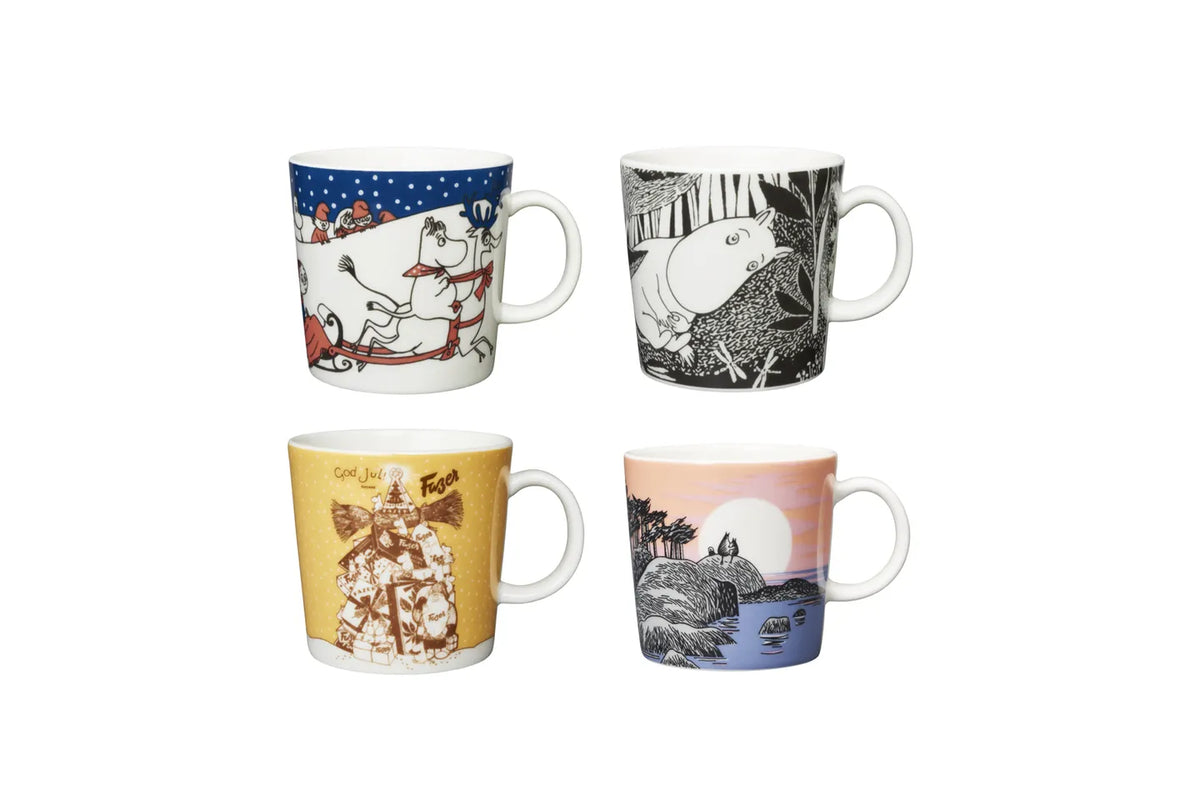 Four Moomin mugs with illustrated designs on a white background